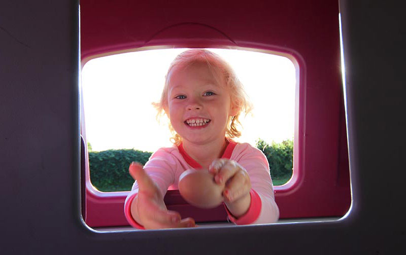 Girl smiling collecting eggs from Omlet Eglu Cube Chicken Coop