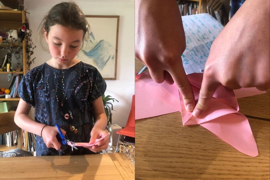 meisje maakt een zelfgemaakt origami kattenspeeltje