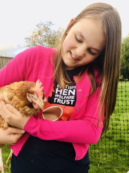 girl holding an ex battery chicken