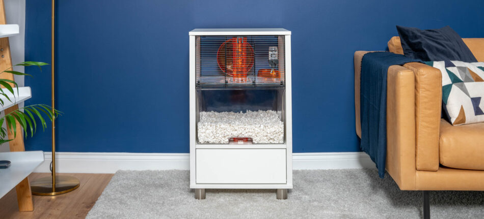 cage blanche pour hamster avec plateau de litière transparent contre un mur peint en bleu dans le salon
