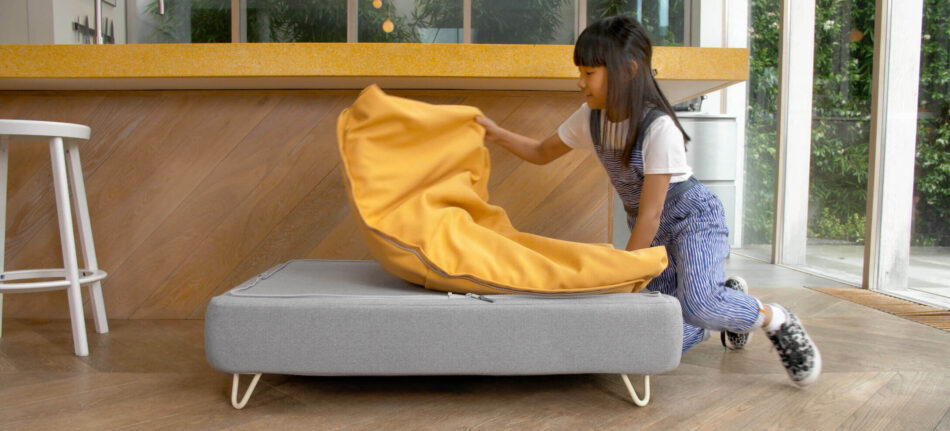 Girl removing yellow washable cover from topology dog bed to keep clean from common allergies in dogs