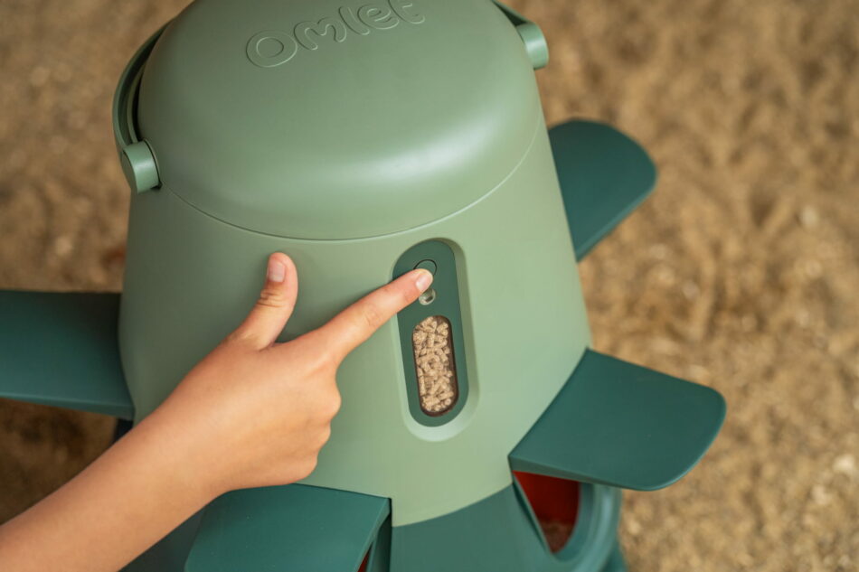 girl pressing button on omlet smart feeder