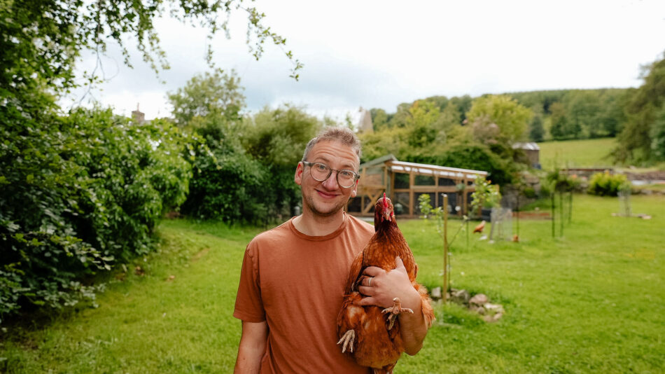 Jude Harper holding his chicken in his garden