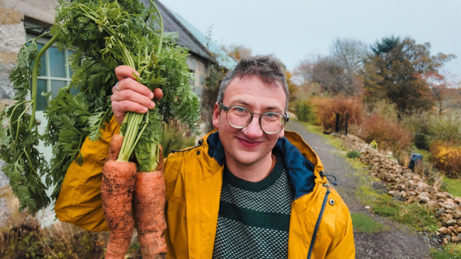Jude Harper holding up his home grown carrots